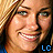 A pixelated close-up of a smiling person with blonde hair, wearing a blue garment, with 'LC' text in the corner.