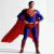 Superman stands in a blue and red costume with a red cape, hands on hips, against a white background.