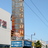 Pixelated static image of a tall building with a blue sky background, featuring a white structure with a window on the left and a blue section near the bottom.