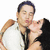 Pixelated image of two people in close embrace, one in white shirt and dark tie, the other in dark clothing, against plain white background.
