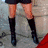 A four- shows a person in school uniform with black shorts, white shirt, red tie, and knee-high boots; the bottom-left includes text