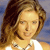 Static pixelated image of a person with long brown hair wearing a white top against a blue background.