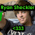A person wearing headphones and a dark gray shirt with white text, holding a green object in the left hand. The top-left corner displays 'Ryan Shuckler' in bright green pixelated font.