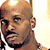A 2x2 contact sheet of four animated frames showing a bald Black man in various poses and expressions with different backgrounds and clothing.