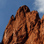 Brown rocky formation with textured surface against blue sky background, no visible text or additional elements.