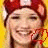 A pixelated image of a person wearing a red cap with white accents, smiling against a yellow background.