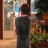 Animated contact sheet showing a person in dark clothing standing with back to viewer, facing a window with outdoor scenery and plants, transitioning from upright posture to bending forward across three frames.