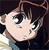 Pixelated close-up of a character's face with dark hair, large eyes, and a neutral expression against a dark background.