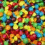 Pixelated rainbow-colored candy-like shapes fill the left side, while right side displays 'Colors of the rainbow' text in blue, purple, and red pixel fonts.