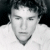 A split-screen image shows two black-and-white photographs of a person with curly hair, one above the other, next to text reading "Heath Ledger" on a dark background.