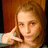 A pixelated image of a person with light brown hair holding a dark-colored phone to their ear against a warm-toned background.