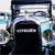 Static pixelated image of a dark vehicle with light blue and white accents, featuring a rectangular front grille and visible headlights.