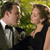 A pixelated image shows two people in formal attire embracing outdoors with greenery in the background.