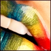 Close-up of lips with rainbow gradient colors and visible teeth, rendered in pixelated style.