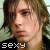 A 50x50 pixel animated contact sheet showing two side-by-side frames of a person with long brown hair wearing a black shirt, each frame displaying the word "sexy" in white text at the bottom.