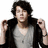 Pixelated image of a person with dark hair wearing a black jacket over a light gray shirt, arms raised in fists against white background.