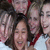 A static pixelated image shows multiple people in a group pose with one central figure smiling broadly, surrounded by others partially visible.