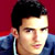 Static pixelated image of a person's face and upper shoulders against a red background with blue clothing details.