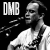 Black-and-white pixelated icon featuring a side-profile of a person with short hair wearing a white shirt, alongside the text "DMB" in blocky gray letters on a black background.