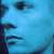 Pixelated blue-toned static icon showing partial facial features with dark accents on a light blue background.