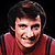 Two side-by-side pixelated frames of a man in a red jersey with dark stripes, showing different facial expressions against a black background.