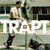 A pixelated image with a person in military attire holding an object, overlaid by large white text reading "TRAPT" and a red square symbol.