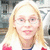Pixelated image of a person with long blonde hair wearing glasses and red nail polish, static composition.