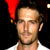 Static pixelated image of a person wearing a red pointed hat against dark background with white shirt visible at bottom.