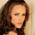 Static pixelated image of a person with long brown hair, light skin, and a neutral expression against a light background.