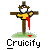Pixelated static image of a scarecrow-like figure on a cross with red fabric, standing on grassy ground beneath the text "Cruicify".