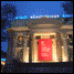 Four distinct pixelated scenes arranged in a : a building with red door at night, colorful blocks with lamp, orange wall with green dots, and yellow spiral with silhouette