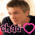 A pixelated image of a person with short brown hair wearing a black shirt, featuring pink text and heart symbols in two states.