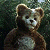 A pixelated cartoon bear on the left side of a split image with green text reading "Original Icons .com" on the right against a dark background.