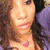 A person with long brown hair wears a purple garment and a pink heart-shaped pendant, shown in four with subtle facial and head position changes