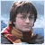 Pixelated static image of a person with dark hair wearing a brown and red garment against a blue background.