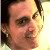 Pixelated close-up of a person's face with dark hair, visible eye, nose, and mouth against a light background.