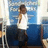 Pixelated static image of a person in white shirt and dark pants standing against blue background with light-colored vertical elements.