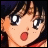 Pixelated anime-style character with brown hair and large blue eyes, mouth open in surprise, against black background with white text.