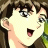 Anime-style character with brown hair and wide eyes, mouth open in surprise, next to black background with white text.