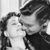 Black-and-white pixelated image of two figures in close proximity with one figure's head tilted toward the other's face.