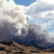 Pixelated landscape with layered clouds, blue sky, and dark ground, rendered in low-resolution style with visible pixelation.