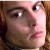 Pixelated close-up of a person's face with light skin tone, brown hair, and dark eyes, showing a neutral expression with slightly parted lips.
