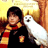 Pixelated static image of a person with dark hair wearing a black top and red-yellow striped scarf holding a white dog against warm-toned background.