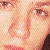 Pixelated close-up of a person's face showing eyes, nose, and mouth with light skin tones and a dark hair section on the right edge.