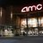 Pixelated static image showing a building facade with illuminated signage reading 'AMC' above a row of windows and a dark lower section.
