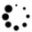 Black circular shapes of varying sizes scattered across a white background with a gray rectangular block in the bottom right corner.
