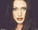 A woman with long dark hair and red lipstick appears in multiple poses against varying backgrounds, including solid colors and a light gradient.