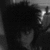 Black-and-white pixelated image of a person with dark hair and light skin, side profile facing right, showing partial facial features and neck. Purple text "ddii" appears vertically on the right edge.