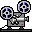 Two pixel-art film projectors with blue-and-black reels, gray bodies, white accents, and red indicator lights on a light gray background.