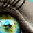 A pixelated close-up of a character's face with dark hair, showing a portion of the eye and cheek area against a light background.